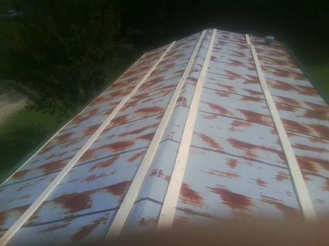 Rusted metal roof panels with new wood purlins before replacement — Storm Damage Roof Repair in Redmond by Roofing Brothers