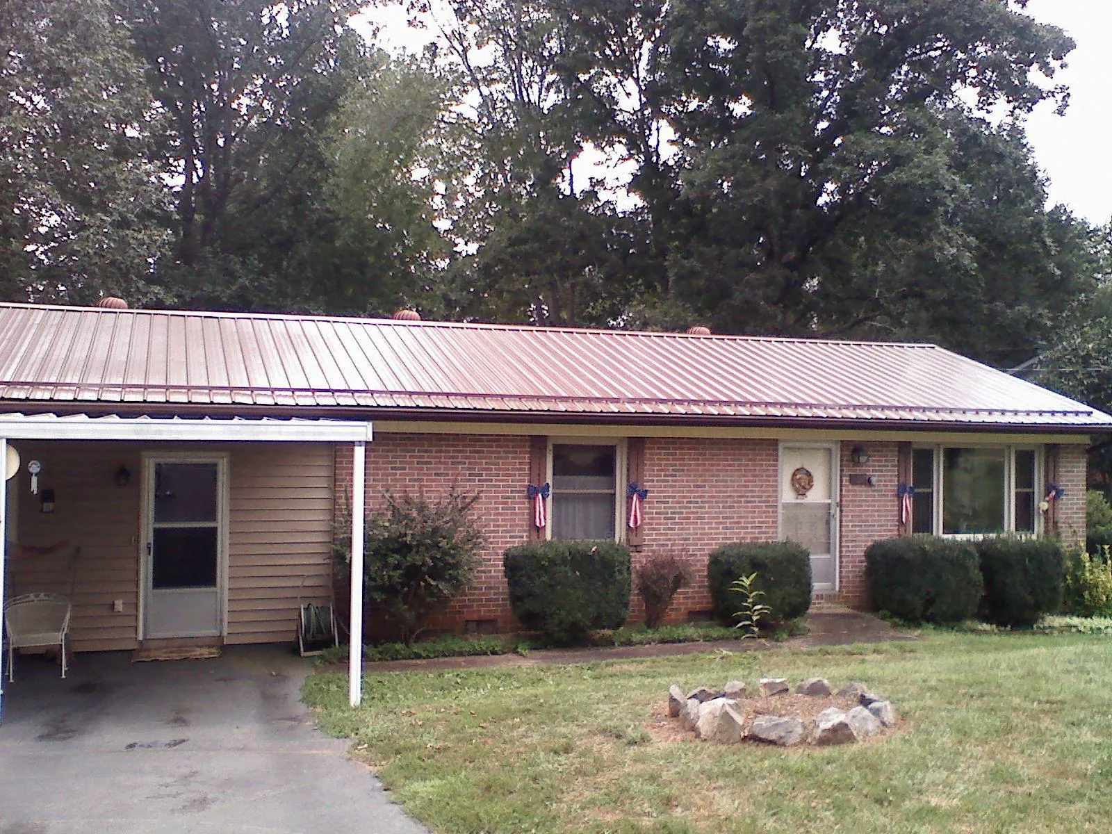 Bronze metal roof and carport on a brick ranch home — Roof Repair work by our crew in Redmond